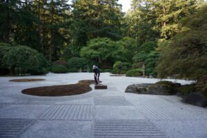 Portland Japanese Garden gardener Caleb Hendrickson rakes the special checkerboard pattern in the Flat Garden for Moonviewing.